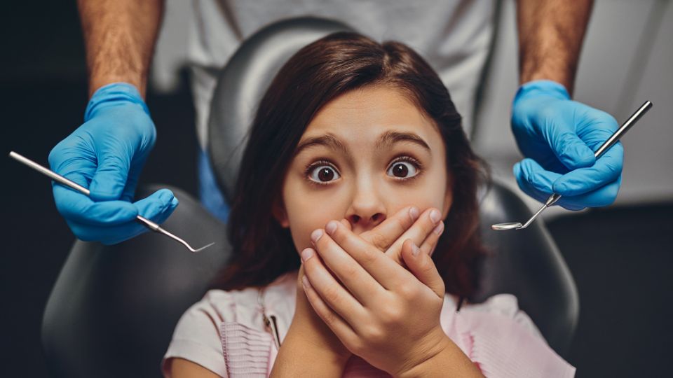 Girl Sitting in Dental Chair With Fearful Expression